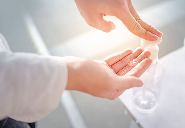 手のアルコール消毒をしている様子